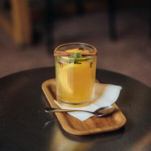 Vibrant orange cocktail garnished with mint on a table, perfect for summer.