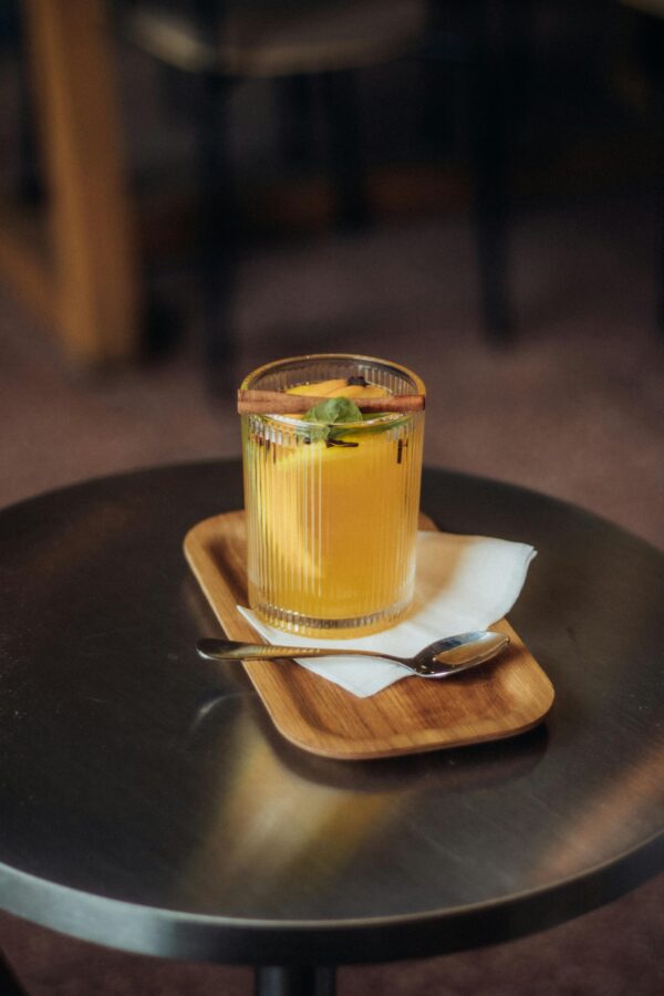 Vibrant orange cocktail garnished with mint on a table, perfect for summer.